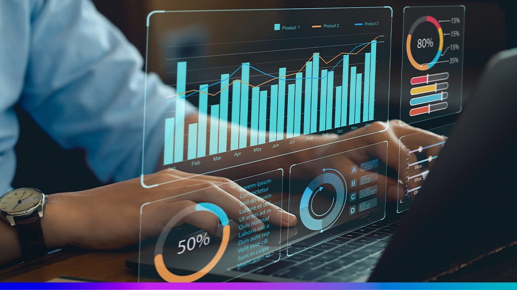 Mãos no teclado de notebook com dashboards de dados — gráficos de barras e pizza — simbolizando Business Intelligence.