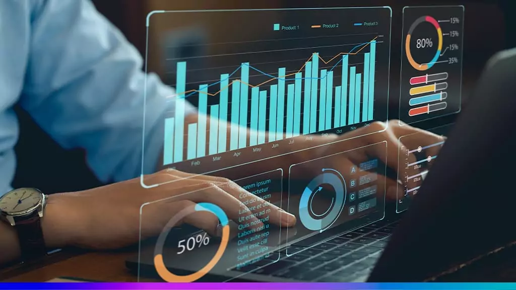 Mãos no teclado de notebook com dashboards de dados — gráficos de barras e pizza — simbolizando Business Intelligence.