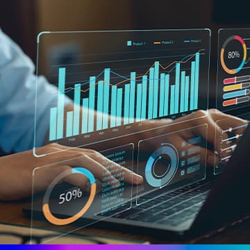Mãos no teclado de notebook com dashboards de dados — gráficos de barras e pizza — simbolizando Business Intelligence.