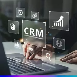 Pessoa usando notebook com ícones digitais flutuantes representando ferramentas de CRM, como gráficos, e-mail e pesquisa.