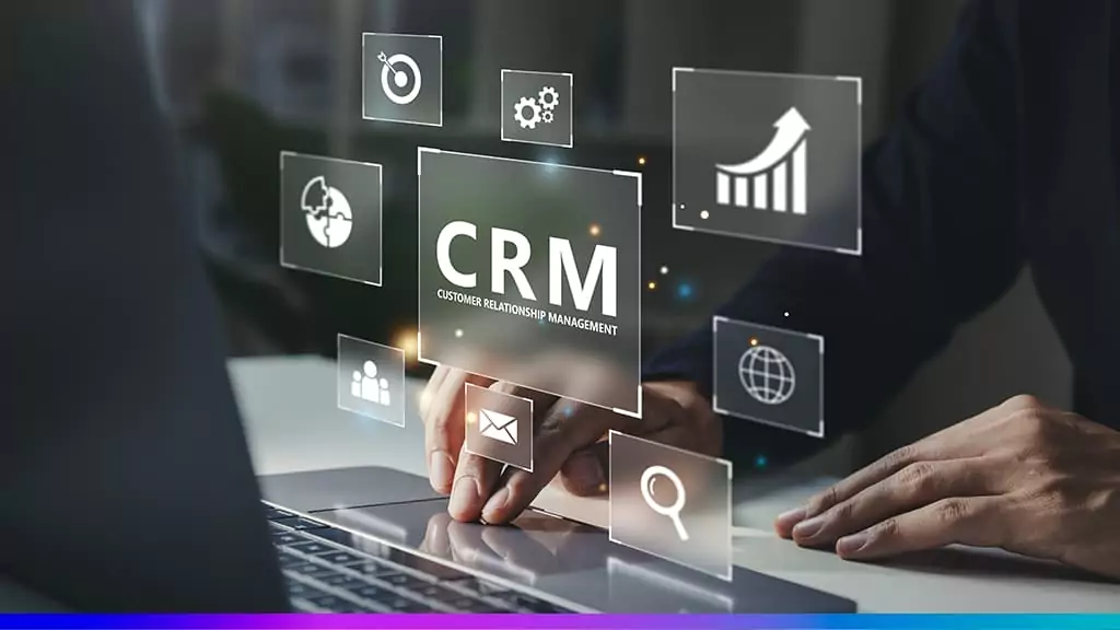 Pessoa usando notebook com ícones digitais flutuantes representando ferramentas de CRM, como gráficos, e-mail e pesquisa.