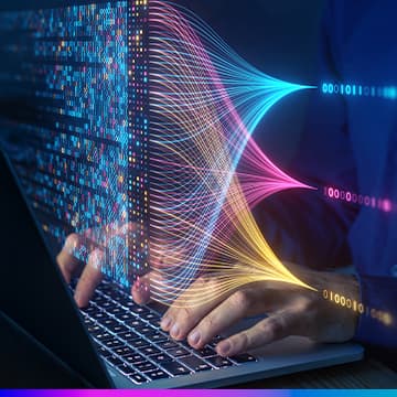 Pessoa digitando em notebook com fluxos de dados coloridos representando o conceito de Big Data e análise de informações para aprimorar a experiência do cliente (Customer Experience).