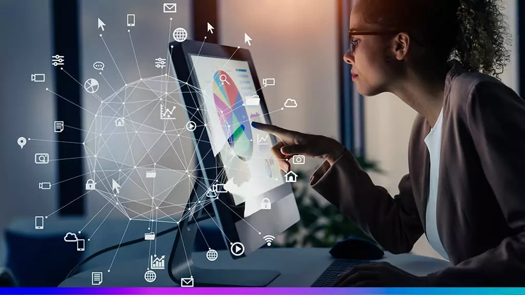 Pessoa analisando gr&aacute;ficos em uma tela de computador com &iacute;cones de tecnologia e rede digital sobrepostos, representando an&aacute;lise de dados e IA.
