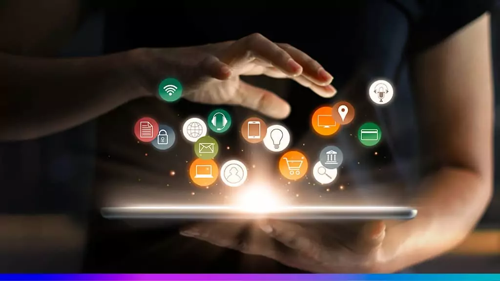 Mãos em volta de uma luz brilhante com ícones flutuantes de tecnologia, marketing digital e e-commerce (Wi-Fi, e-mail, celular, carrinho de compras, localização e documentos).