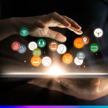 Mãos em volta de uma luz brilhante com ícones flutuantes de tecnologia, marketing digital e e-commerce (Wi-Fi, e-mail, celular, carrinho de compras, localização e documentos).